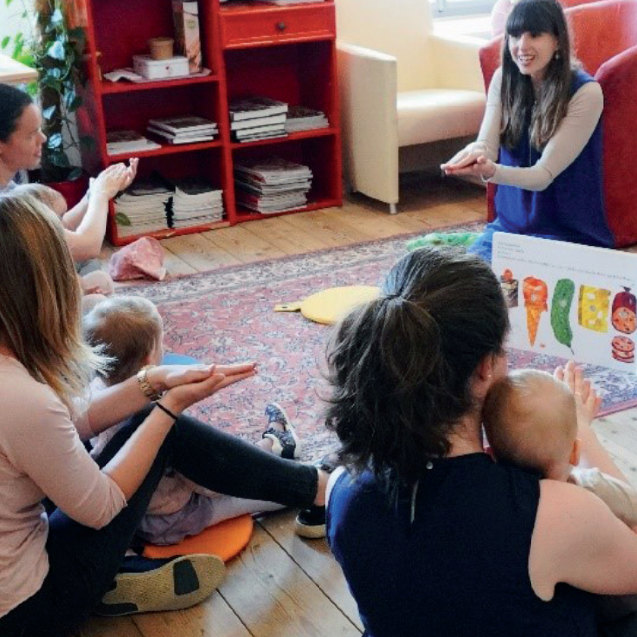 Frauen mit Kleinkindern von hinten und vorne eine Frau, die Fingerspiele vorzeigt
